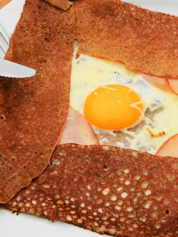 galette complete. traditional french buckwheat pancake with egg, cheese and ham served at typical breton pancake restaurant (creperie).