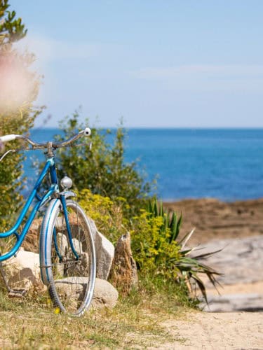 vieux vélo bleu au bord de la mer sur le littoral breton, bretagne, france.