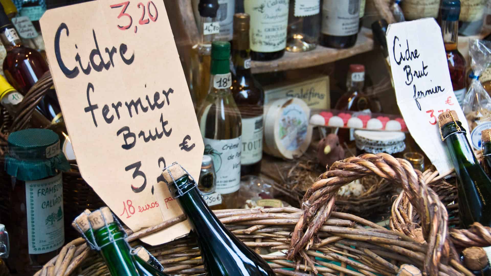 vente de bouteilles de cidre fermier brut, étal de produits locaux, gastronomie française sur un marché régional en france